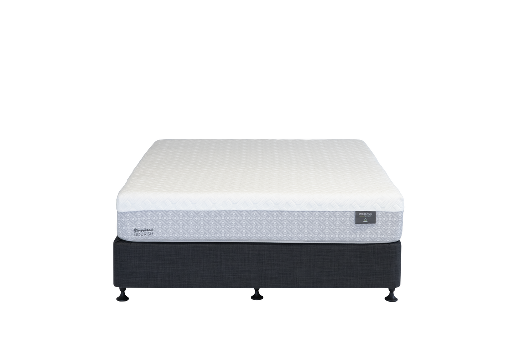 A Sleepyhead mattress on a dark upholstered box spring with small feet, shown against a plain white background. The mattress has a white quilted top and a patterned gray side panel.