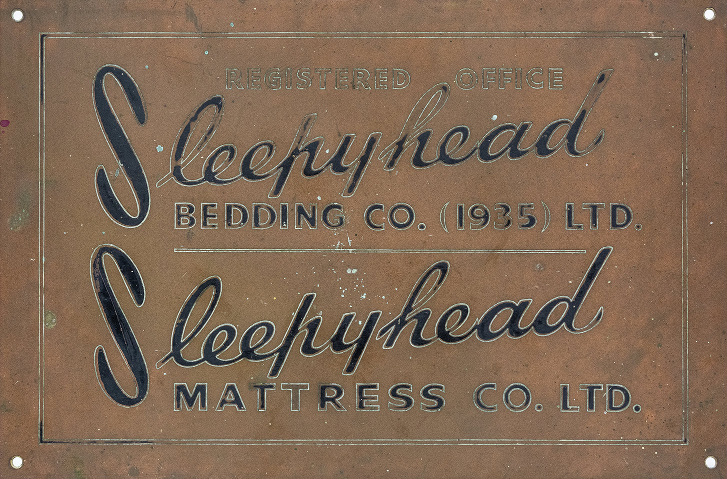 Brass sign with 'Sleepyhead' branding on a textured background