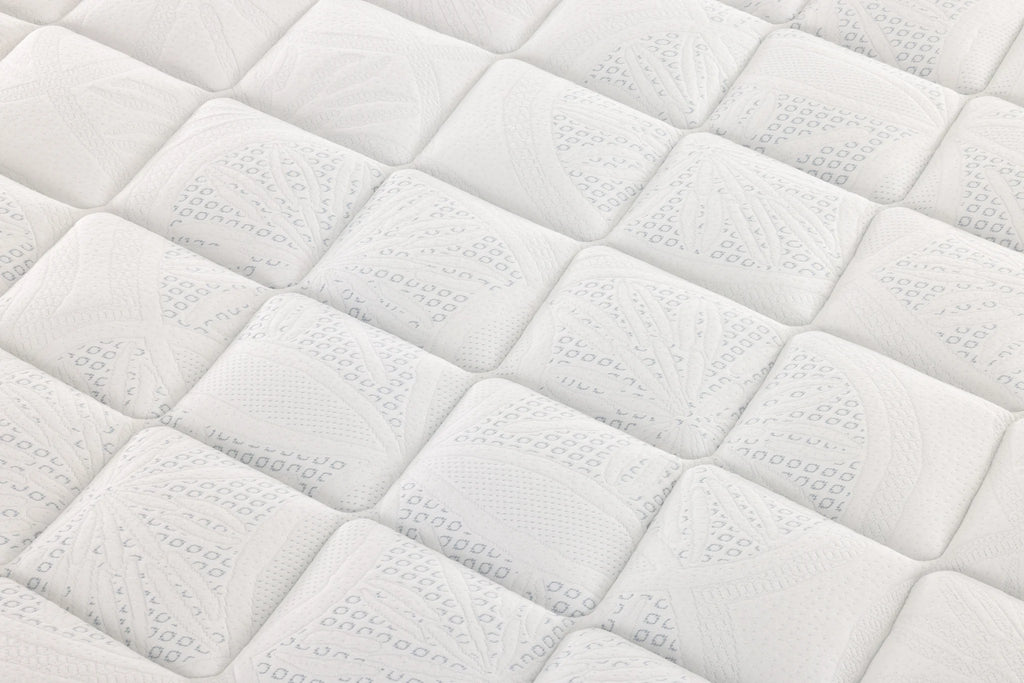 Close-up of a white Sleepyhead mattress surface with repeating square tufts and subtle embossed leaf-like patterns.