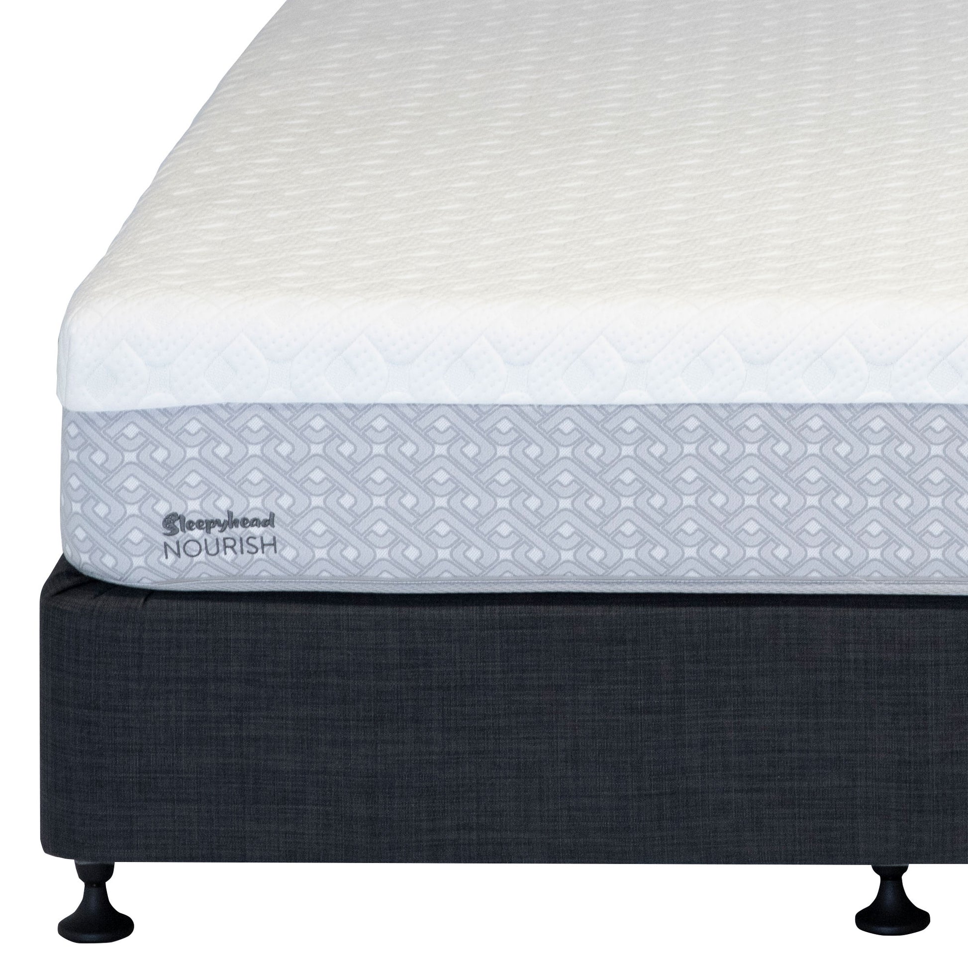 A close-up studio shot of a mattress corner on a bed frame. The mattress has a white quilted top surface and a light gray patterned side panel with the visible brand text 'Sleepyhead NOURISH'.