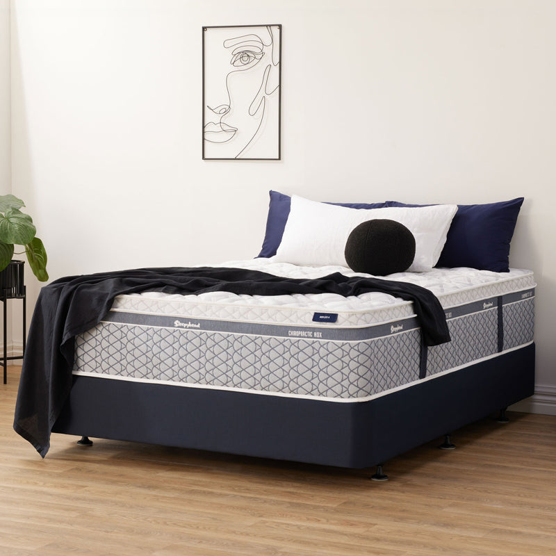 Sleepyhead Chiropractic mattress with pillows and blanket in a bedroom setting