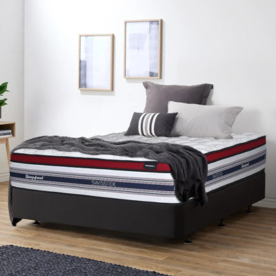 Sleepyhead Swisstek mattress in a bedroom setting with pillows and a blanket.